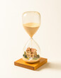 © Ina Krel - Hourglass with a miniature house inside symbolizing time and real estate investment.