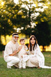 © JJ Studio - Happy Young Family With Toddler Posing Outdoors In Park During Warm Golden Hour