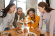 © Maria Vitkovska - Group of smiling, happy multiracial friends making pizza, dinner in modern kitchen at home