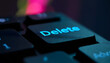 © Yasin - Close-up of a glowing blue 'Delete' key on a dark computer keyboard with bokeh background
