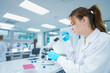 © ultramansk - Pharmaceutical researcher performing precise chemical aliquot application on test slide. Young scientist validating biochemical compound reaction in modern biotech lab.
