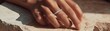 © Tichakon - A delicate ring on a finger resting on a textured surface. The image highlights the ring's design and detail, emphasizing the beauty of the jewelry and hand