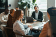 © Maskot - Smiling businesswoman interacting with coworkers sitting in meeting room