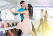 © JackF - Girl and guy in festive clothes dancing slow ballroom dance during group lesson in a choreography studio