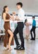 © JackF - Elegant couple performs an expressive latin american dancing in bright, modern dance studio during a group class