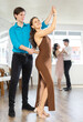 © JackF - With unhurried music, guy with girl in couple spins to rhythm of waltz during lesson for novice students. Classes in mini-groups, participants of class enjoy movement, learn to control body in dance