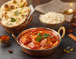 © Mbah Di  - Delicious Indian Chicken Curry Meal Tikka Masala with Naan Bread and Aromatic Rice on Dark Table