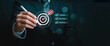 © Mehdi - Business goal setting concept with businessman using digital stylus to target center of dartboard, symbolizing strategic planning, objective alignment, achievement checklist for organizational success