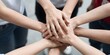 © Studicon - Team of diverse people putting hands together in unity and support for a common goal