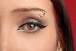 © New Africa - Woman with eyebrow piercing and perfect makeup on red background, closeup