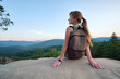 © bilanol - Hiker woman resting on rocky mountain top enjoying summer nature during her travel on wilderness trail. Lonely female traveler traversing high hilltop route. Healthy lifestyle concept