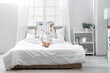© Pixel-Shot - Young woman with newspaper lying in bedroom