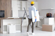 © Pixel-Shot - Male worker with shelf assembling furniture in kitchen, back view