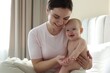 © New Africa - Mother and her cute baby on bed at home