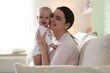 © New Africa - Mother and her cute baby on sofa at home