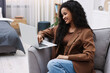 © New Africa - Beautiful young woman with laptop on sofa at home