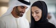 © NovaVision - Smiling Arab couple in traditional clothing collaborating on a project in a modern office setting