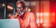 © NovaVision - Smiling African American man with glasses and beard looking at laptop screen