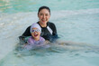© geargodz - cheerful preschool child girl playing and swimming with her mother in pool