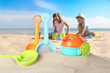 © New Africa - Beach toys on sand and children playing by sea, selective focus