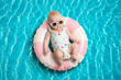 © New Africa - Cute little baby with sunglasses on inflatable ring in swimming pool, above view