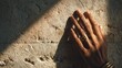 © 楠 刘 - Dark Mediterranean hand gently touching modern Jerusalem stone wall with warm shadows and minimal luxury spa aesthetic.