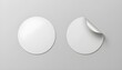 © Momina - Blank white round adhesive stickers are perfectly arranged on a minimalist light gray background, offering a versatile template for product branding and design mockups, with one sticker featuring a re