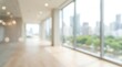 © CuteBee - A softly focused, bright interior view of an empty modern office hallway or corridor with large windows offering a blurred city skyline background.