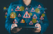 © Nirusmee - Geopolitical risks and global instability concept with businessperson holding world map and warning icons, assessing impact of international conflict, trade wars, and economic uncertainty.