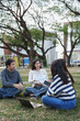© crizzystudio - Students discussing company reports during outdoor presentation