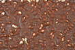 © nahhan - A top down close up view of the bumpy surface of a milk chocolate bar filled with crispy puffed rice pieces creating a rich brown food texture