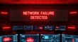 © Shabbir - A dimly lit server room with multiple computer screens displaying red alerts, a large sign reading 'Network Failure Detected' in red light, indicating a critical system failure or cyber attack.