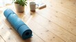 © MuhammadDaffa - Blue yoga mat ready for a tranquil home workout or mindful meditation on a sun-drenched wooden floor, symbolizing wellness, balance, and a peaceful start to the day