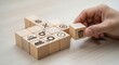 © su - Lean manufacturing principles and removing unnecessary cubes from the layout using wooden cubes, symbolic icons, human hand, natural depth of field, soft blurred background, minimal desk background.