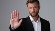 © Marina Priz - Serious businessman in suit showing stop hand gesture on neutral background in studio portrait