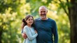 © Jhon - Father and daughter sharing a moment outdoors, bathed in soft sunlight with a green backdrop.