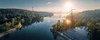 © Rifqi - Aerial shot of solar farm and turbine near a forest lake, contrasting with a distant city skyline at bright sunrise, concept for renewable energy usage, ecological transition and climate action