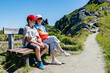 © Elena Medoks - Brother and sister resting on bench during mountain hike
