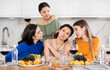 © JackF - Group of attentive and caring female friends gathering around table to console upset bestie during friendly get-together with wine at home..