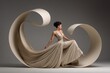 © DSimage - Elegant woman in a flowing beige gown poses gracefully within large abstract swirling fabric shapes against a neutral studio background.