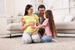 © New Africa - Pregnant woman, her husband and daughter on floor at home