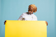 © DC Studio - African American woman in chef coat standing in studio with yellow placard. Professional cook holds empty banner for restaurant branding, food industry advertisement and culinary marketing campaign.