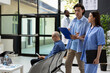© DC Studio - Registered nurse talks with male patient during medical checkup at modern clinic lobby. Healthcare consultation emphasizes professionalism, trust and effective patient communication in hospital.