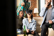 © DC Studio - Caucasian woman wearing VR glasses and holding gamepad, immersed in 3D online gaming as friends watch. Diverse group bonding and reacting to female individual in virtual reality experience in