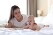 © New Africa - Mother and her cute baby on bed at home. Space for text