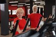 © New Africa - Senior couple training on elliptical machines in gym