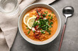 © Pixel-Shot - Bowl of tasty lentil soup with parsley and lemon on grey background