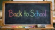 © Yuliia - Colorful chalk text Back to School written on black chalkboard with wooden frame and colored chalks, education concept for classroom learning and academic year.