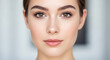 © Aleena Javed - A close-up portrait of a young woman with fair skin and light brown hair, groomed brows, pink lips, and a soft, neutral background, HD and 4k image