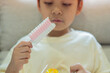 © Kunlathida - Cute little Asian child sitting at the livingroom and eating marshmallows.